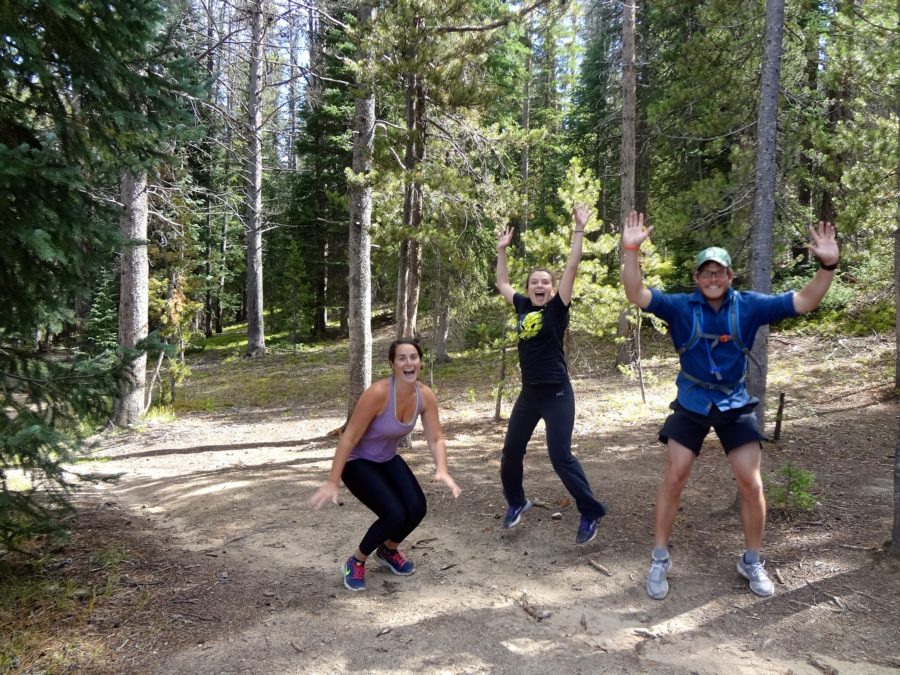 Three people try jumping in air for a timed photo.