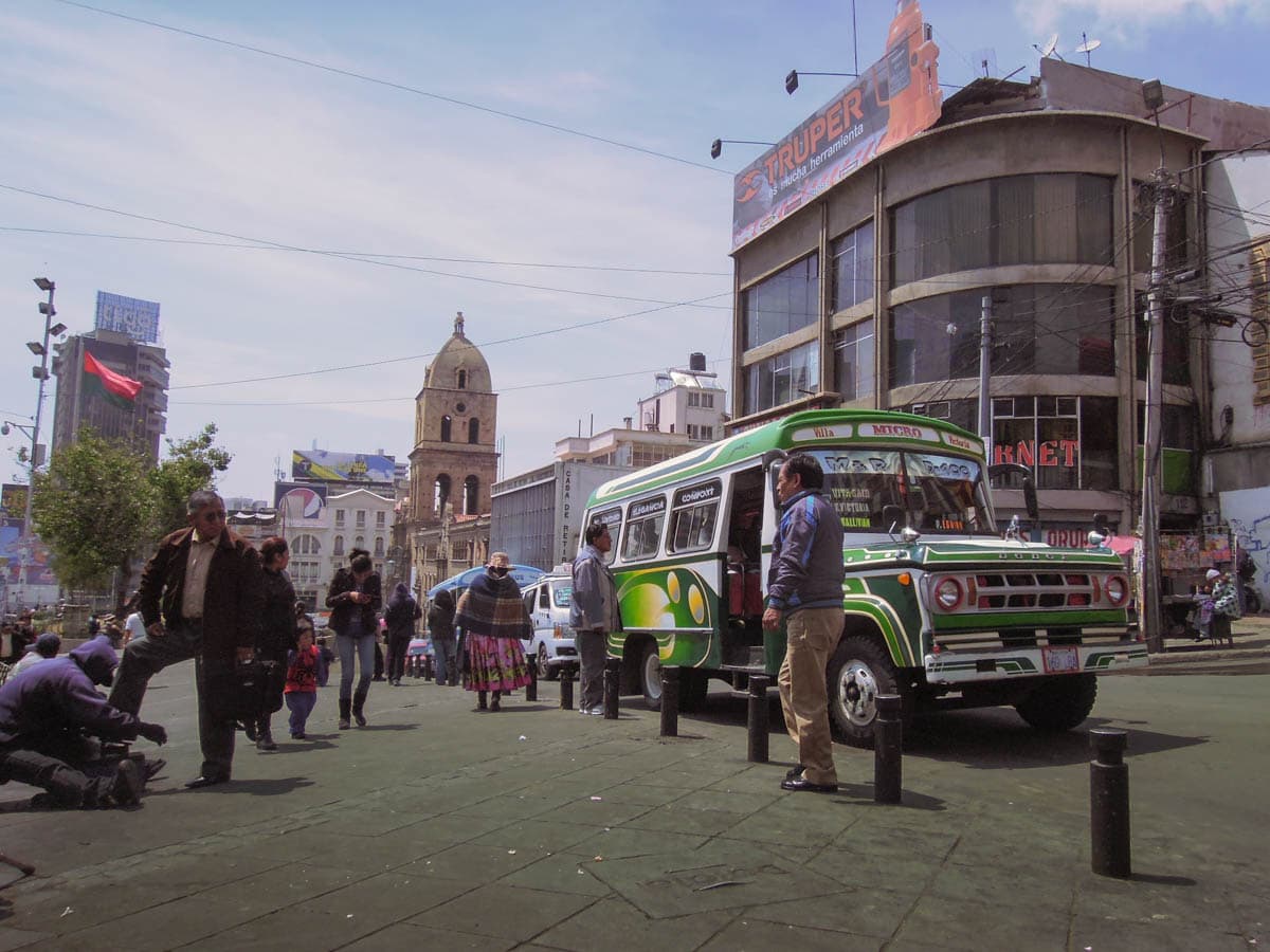 Downtown la paz with people and a bus in view.