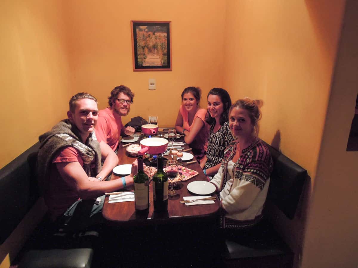 People around table eating swiss fondue.