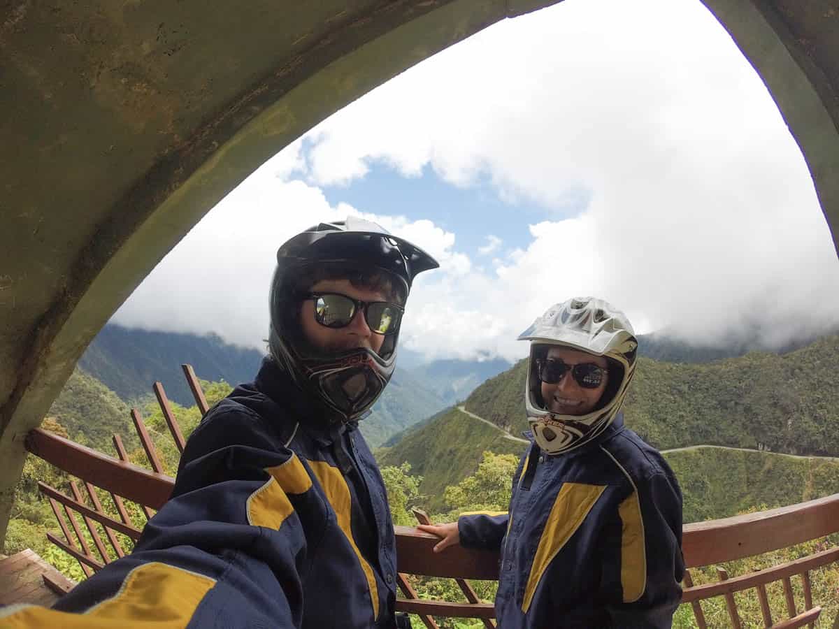 Young couple with helmets on take selfie in canyon.