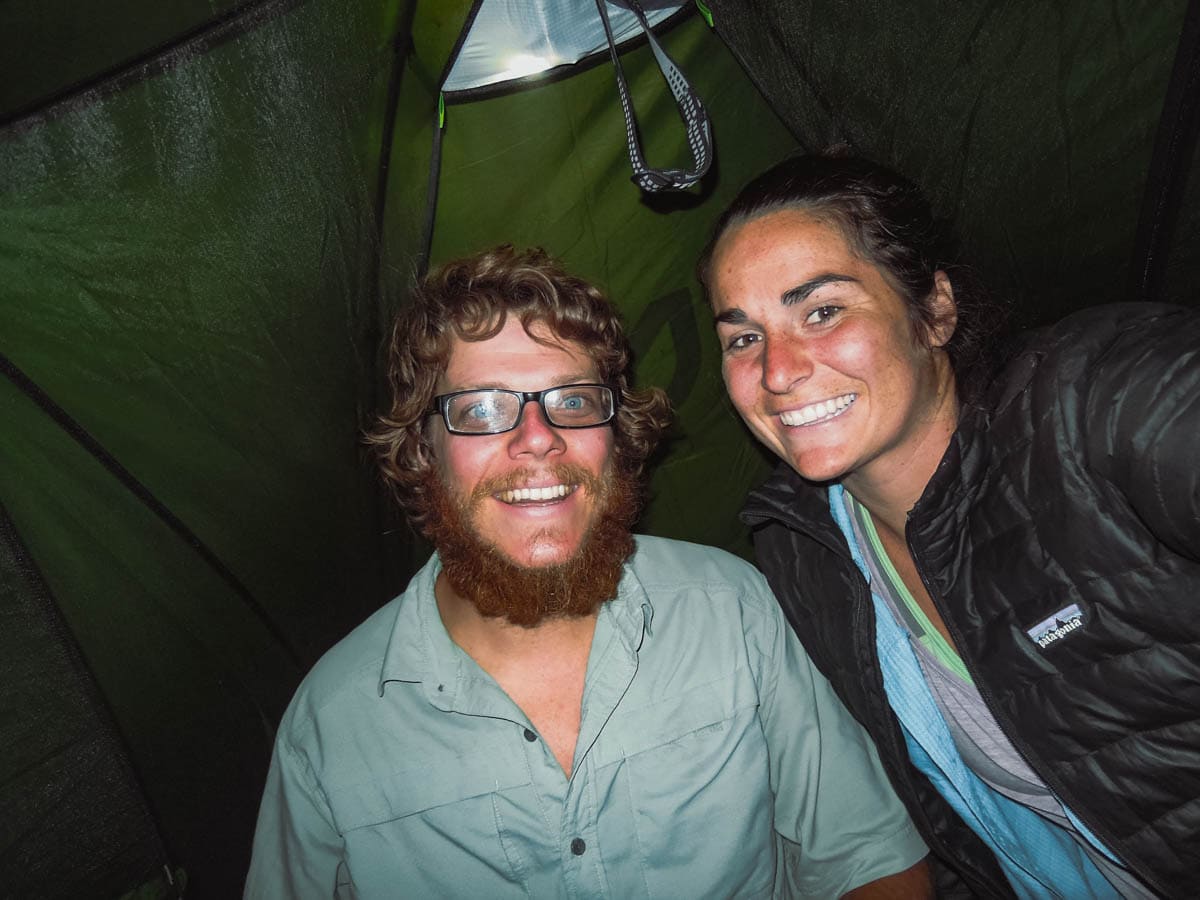 YOung couple in a tent at night.