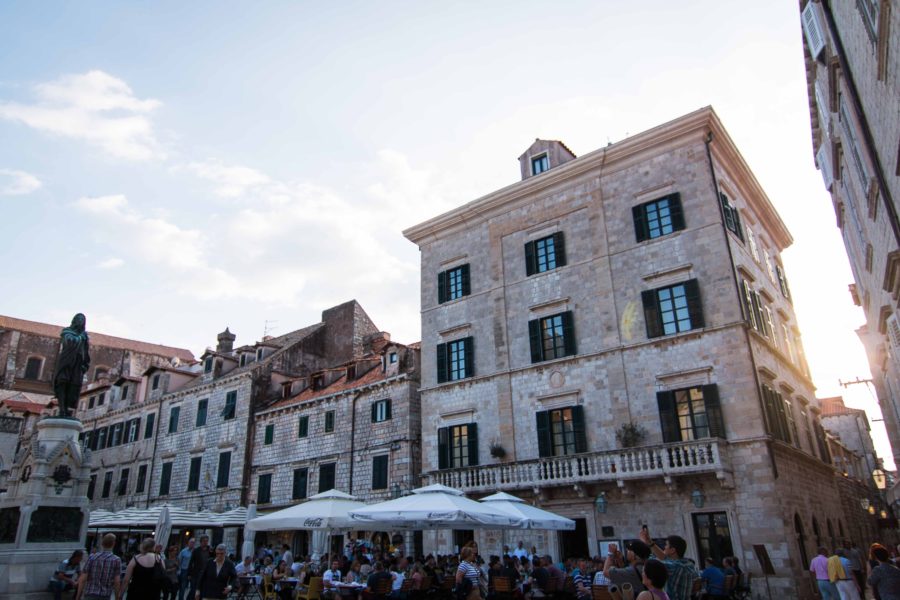 restaurants with white tents over tables outside buildings