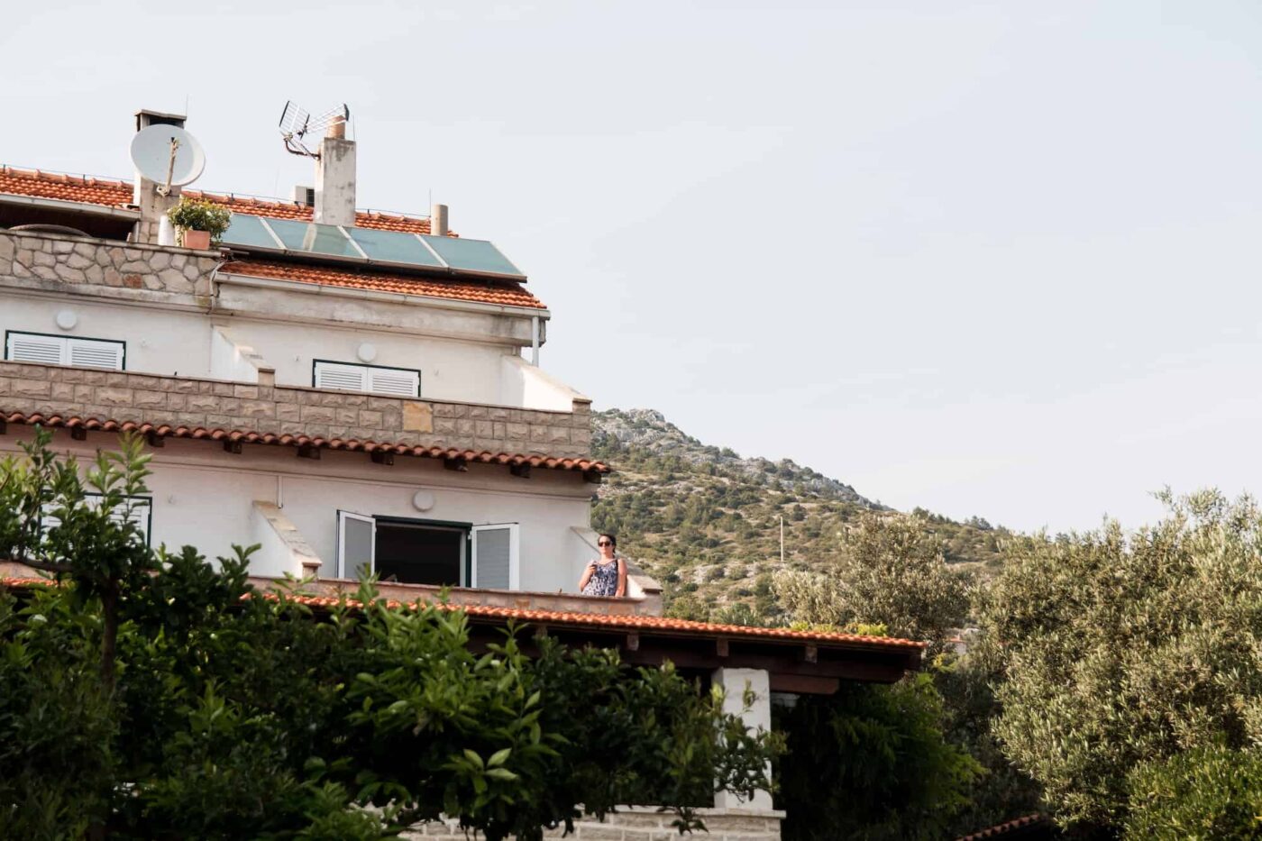 Woman Stands on a balcony of a hotel in Croatia