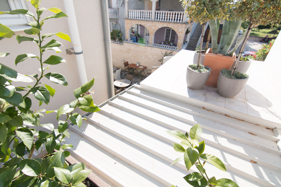 looking down at patio set from terrace with plants on the rooftop