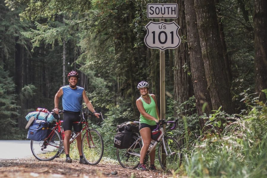 couple at Highway 101 South sign with bike, bike touring the PCH