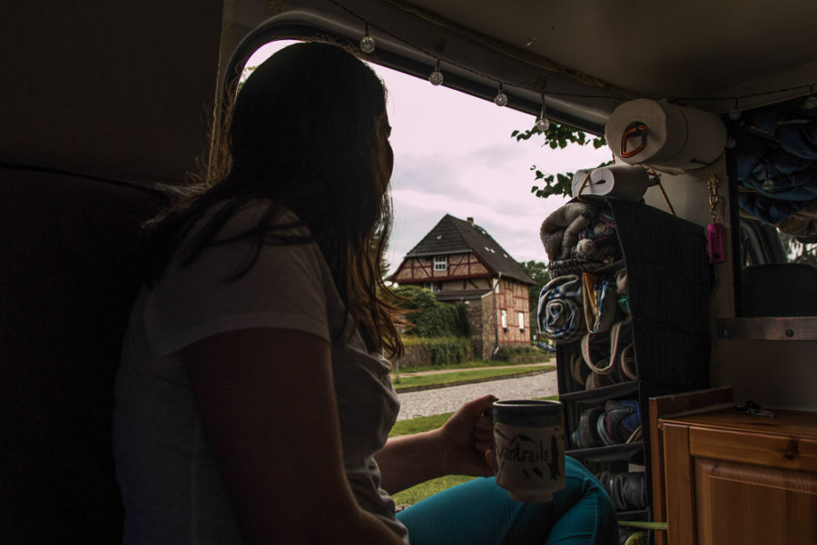 drinking tea in van, vanlife, Germany, woman looking out door, arboursabroad