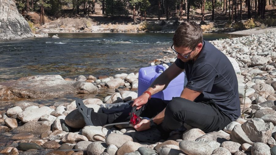 man filtering water from river with a hand pump, arboursabroad, Boise National Forest