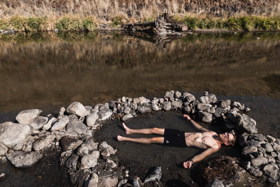 man soaking in hot springs alongside a river, ArboursAbroad