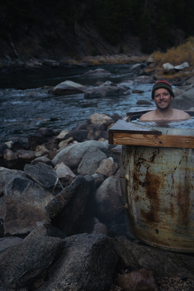 man soaking in hot spring pot next to river, ArboursAbroad, Idaho
