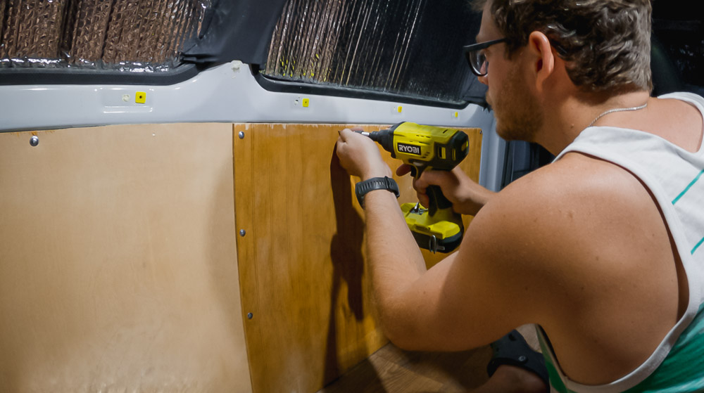man screwing in van panels to metal van frame, arboursabroad