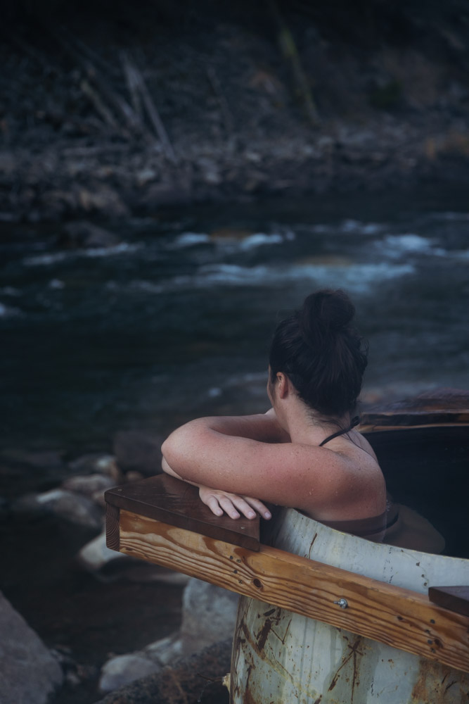 woman soaking in hot spring with river behind, arboursabroad, Stanley, Idaho