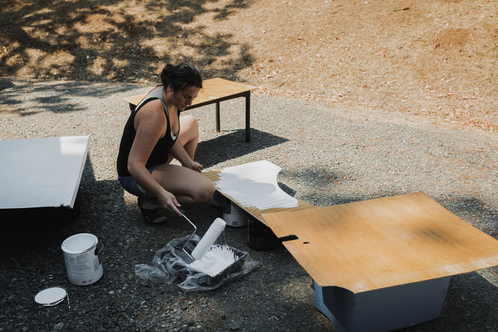 woman priming wood panels, arboursabroad, van build