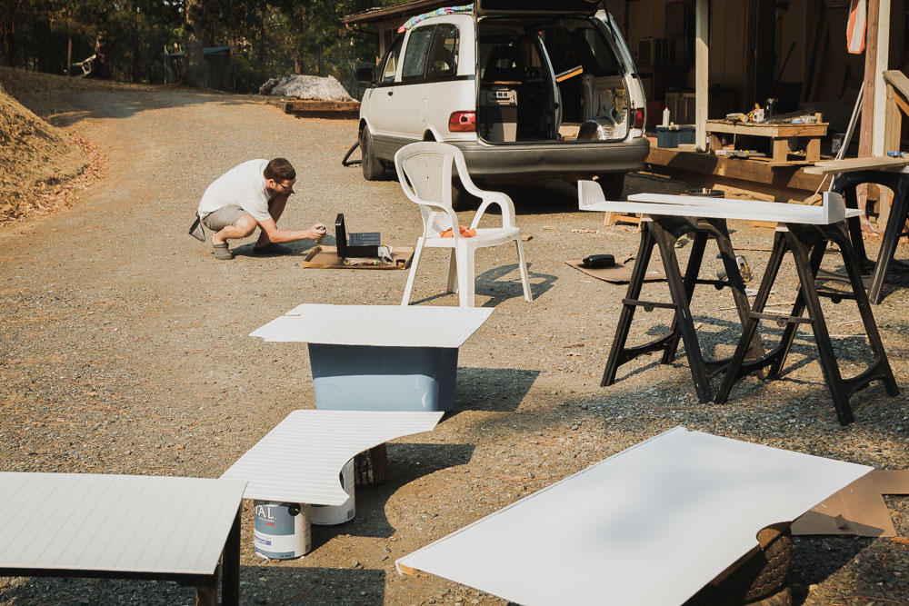 thin plywood painted and drying in sun with work station behind, arboursabroad