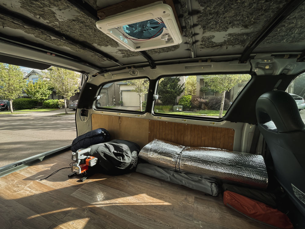 minivan with floor converted, fan in roof, and van panels on walls, arboursabroad