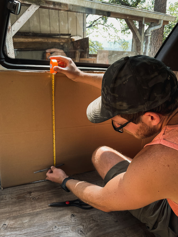 man making cardboard stencil for camper van wall panels, arboursabroad