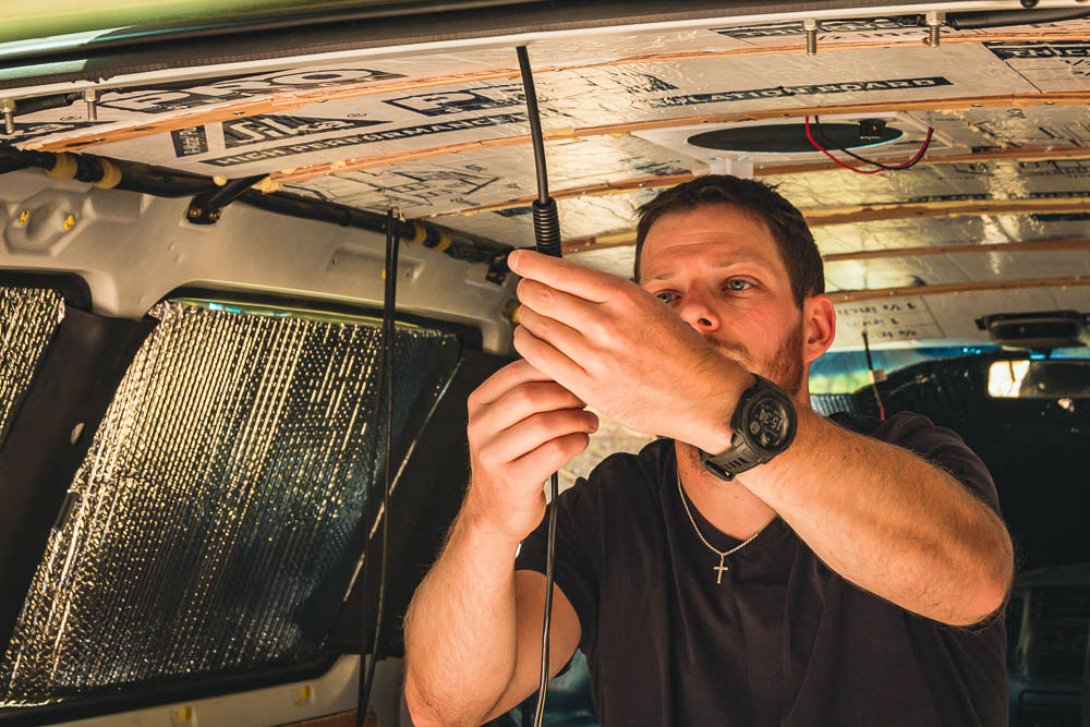 man adding conduit around wiring to protect wires, Arboursabroad