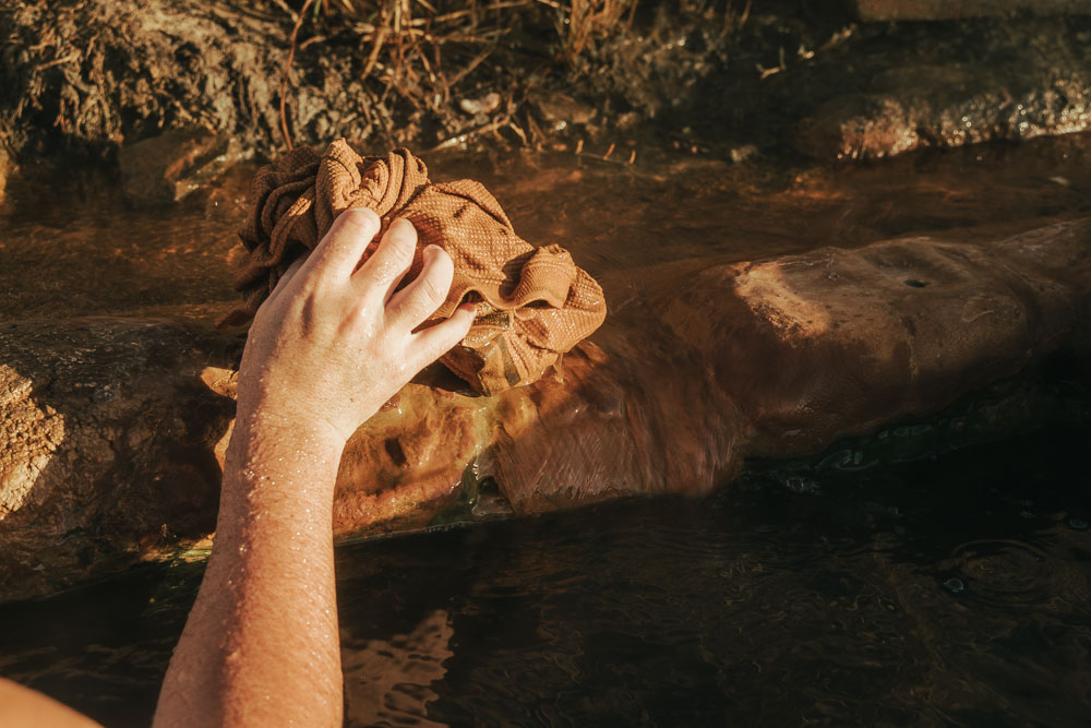 hand with cloth to block hot water from hot spring pool, ArboursAbroad, Baker Hot Spring Utah