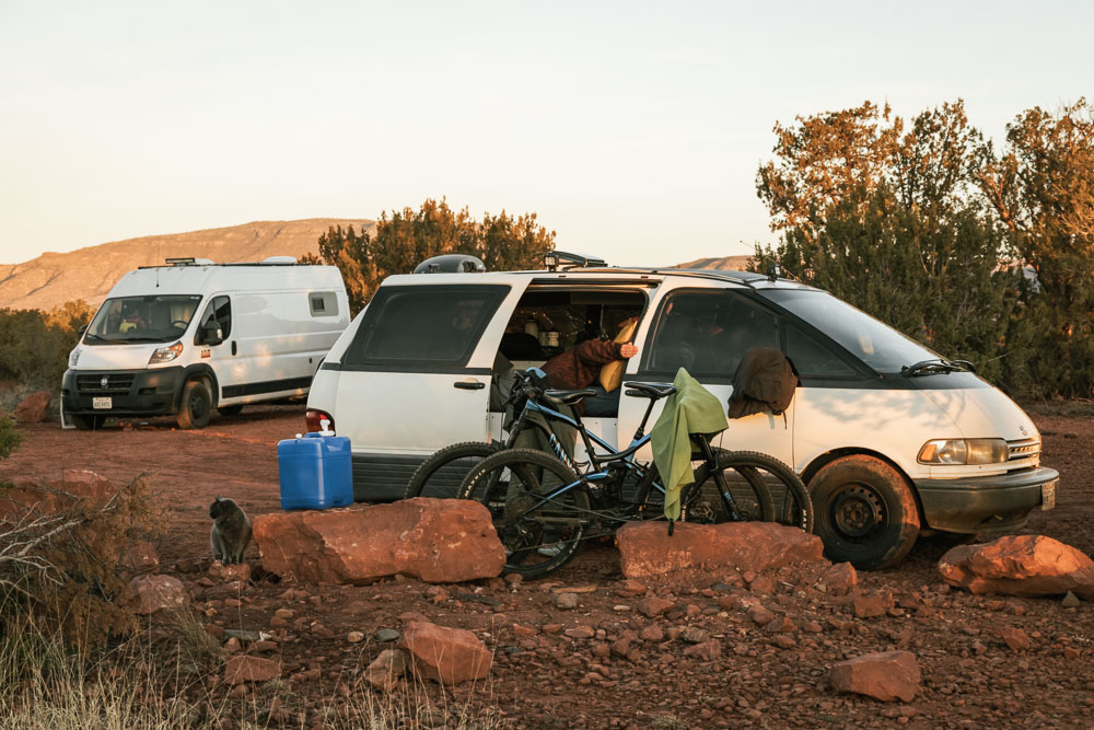 Boondocking in Sedona, Arizona at Nolan Campground -- campervan with shower on roof, door open and bikes, cat, and water jug out front.