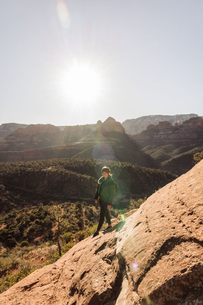A woman hiking on slick red rock in Sedona, Arizona.