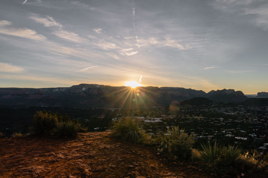 The sun popping up over the mountains in Sedona for sunrise from Sugarloaf Mountain.