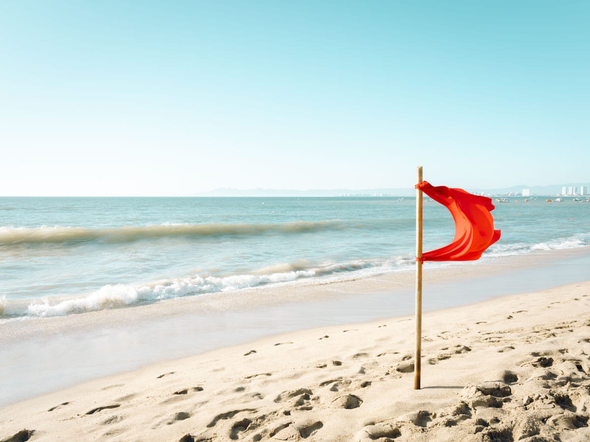 A red flag flying on a beach in Puerto Vallarta warning visitors the water is too dangerous to get in.