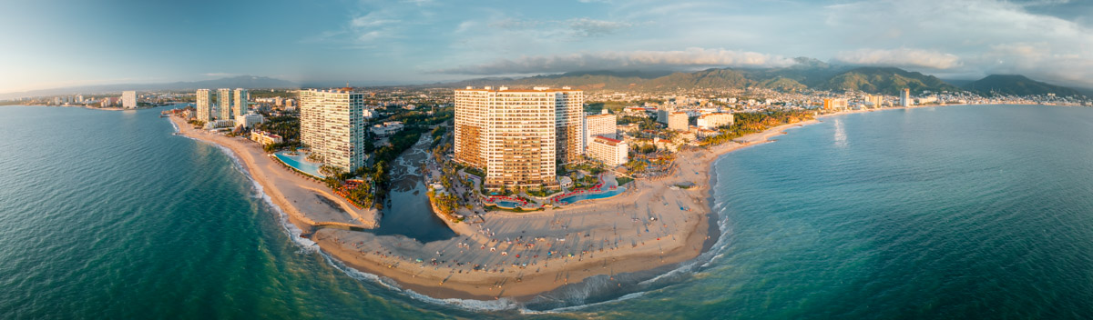 An aerial shot of Playa Flamingos, a beach in Puerto Vallarta right next to hotels and on a corner.