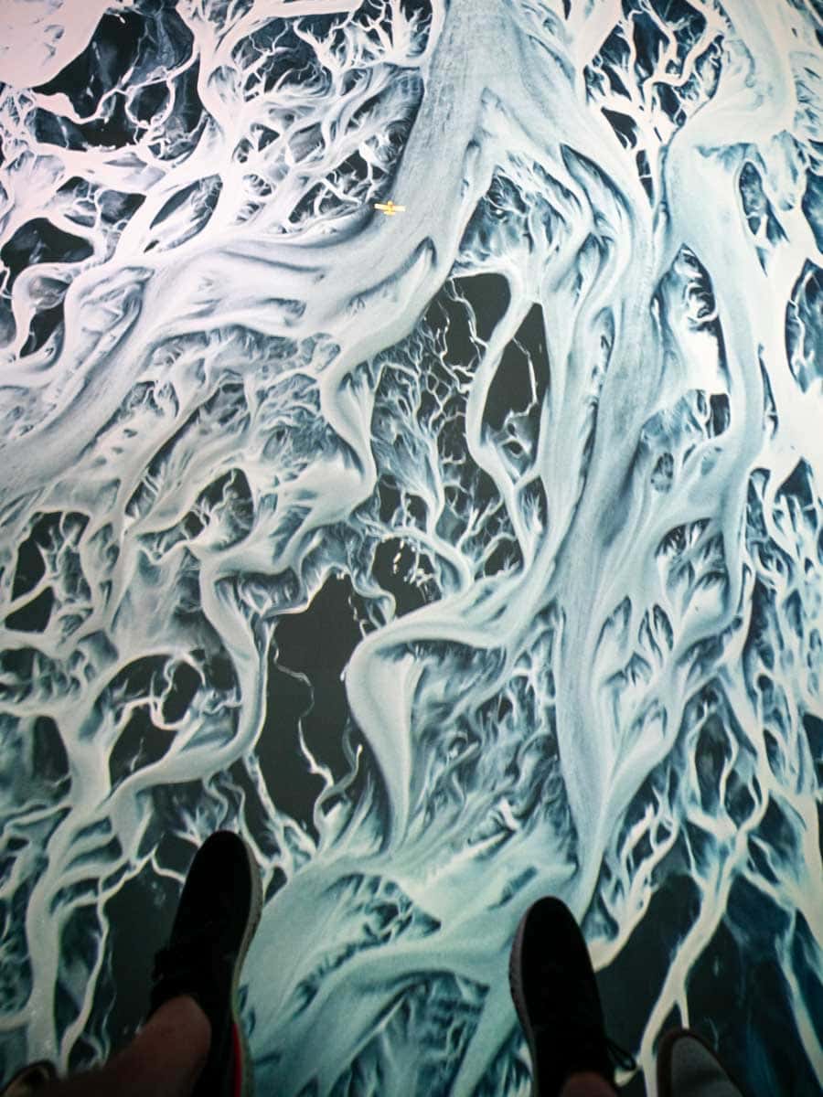 A helicopter view of ice field in Iceland with feet showing in the shot from the Flyover Las Vegas experience.