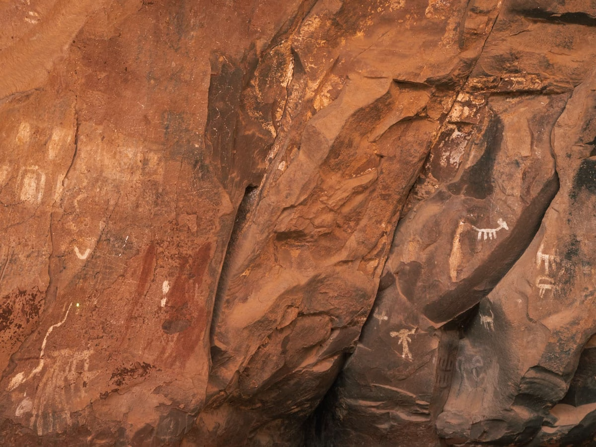 Ancient Wall Art made with white and red paint inside a cave with charcoaled walls at Palatki Heritage Site in Sedona.