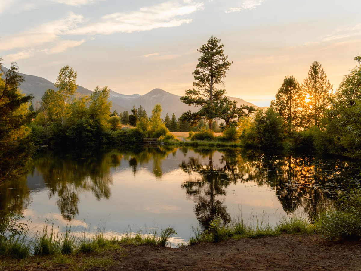 Calm lake reflecting trees and mountains at Iwetemlaykin State Heritage Site near Joseph, Oregon.